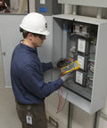 Technician using True-RMS Digital Multimeter Pro Grade Shop-Ready with 6000 Count Scale on electrical panel.