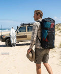 Man carrying Inflatable Kite Surfing Sail And Wing Foil Board Set With Pump, PVC Wing-Shaped Board for surfing on beach