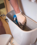 Ivory latex industrial-grade disposable gloves; close-up of gloved hand inside a toilet tank