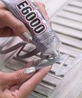 All Purpose Craft Adhesive 3.7 Fluid Ounces Clear Bonds Glass Wood Plastic Ceramic Metal Leather Fabric Rubber Dries Clear Paintable Photo Safe Temperature Resistant Industrial Strength Go To DIY Favorite For Crafts being applied to metal surface.