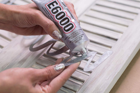 All Purpose Craft Adhesive 3.7 Fluid Ounces Clear Bonds Glass Wood Plastic Ceramic Metal Leather Fabric Rubber Dries Clear Paintable Photo Safe Temperature Resistant Industrial Strength Go To DIY Favorite For Crafts being applied to metal surface.