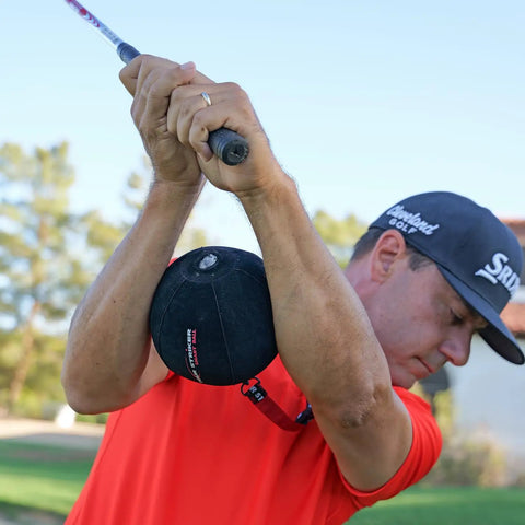 Golfer using Patented Golf Swing Training Ball That Helps You Sync Arms And Body For Real Connection From Takeaway Through Follow Through