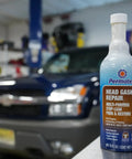 Head Gasket Stop Leak Sealant 16 Fl Oz for Cars and Trucks in front of an SUV in a garage, seals leaks and prevents overheating