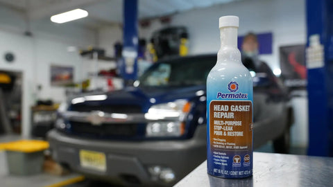 Head Gasket Stop Leak Sealant 16 Fl Oz for Cars and Trucks in front of an SUV in a garage, seals leaks and prevents overheating