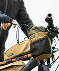 Cyclist adjusts Bongo Bike Handlebar Bag Water Resistant Cordura 1000D Front Stem Bag With Water Bottle Holder on handlebars