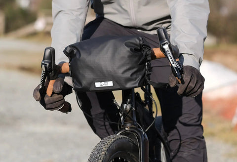 Cyclist using Dayliner Mini Roll Top Handlebar Bag 3 L Waterproof Commuter Sling With Shoulder Strap And Reflective Detail Recycled Ripstop Ideal For City Ride MTB Trek Work Or Weekend Getaways on front of bike