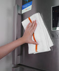 Hand using 60 Pack 16 By 19 Inch Terry Bar Mop Rags For Cleaning Absorbent And Durable Cotton Cloths on stainless steel