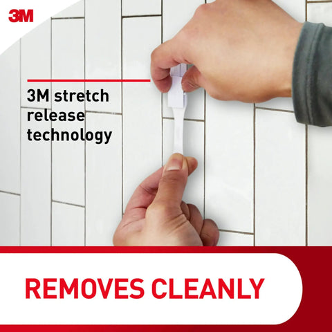 Person demonstrating adhesive strip removal for Large Double Bathroom Wall Hook With Adhesive Strip, Damage Free Hanging For Towels And Robes