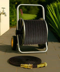 Front view of a 25ft lightweight flexible garden hose on a wheeled reel with brass fittings.