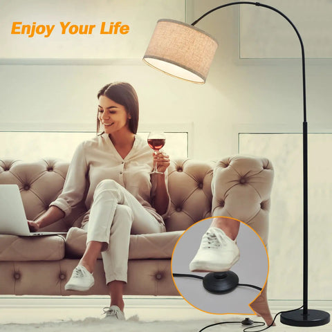 Slick Arc LED Floor Lamp With Marble Base For Living Room, rotatable hanging light over woman on sofa, beige linen shade