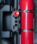 Slick Under Seat Fire Extinguisher Bracket For Ineos Grenadier Truck With One Hand Quick Release Aluminum Mount Kit And Heavy Duty Secure Ratchet Straps displaying fire extinguisher securely mounted.