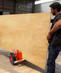 Beefy Heavy Duty Panel Dolly For All Terrain Use With 2 Wheel Slab Design And 10 Inch Solid Wheels, Supports Up To 1100 Lbs, Built Tough For Easy Mobility And Scratch Resistant Iron Construction. Used to move a large plywood panel in a workshop.