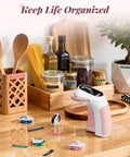 Vintage Embossing Label Maker With Six Adhesive Tape Rolls Manual Typewriter Style Sticker Gun on kitchen table with jars and labels.