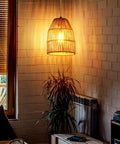 Hand Woven Hemp Rope Pendant Light With 15 Foot Golden Cord And Stepless Dimmer Switch illuminates a cozy room.