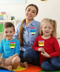Teacher and students wearing Colorful 36 Pack Pencil Desk Name Plates with Waterproof PET Film for classroom organization.