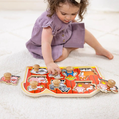 Child playing with Farm Animals Jumbo Knob Puzzle For Toddlers Wooden Peg Puzzle For Early Learning Shape Recognition And Fine Motor Skills Cow Pig Horse On Colorful Barnyard Scene Kid Friendly Educational Toy For Ages 1 And Up on a white carpet