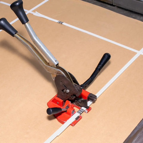 Heavy Duty White Polypropylene Strapping Roll 9900 Ft 1/2 Inch 440 Lb Tensile Strength packing tool on cardboard.