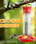 Outdoor Hummingbird Feeders Set Of 2 20 Ounce Plastic Feeders With Five Flower Shaped Ports Cleaning Brush Leak Proof Design Built In Ant Moat Bee Guard Red shown on a tree branch with a hummingbird