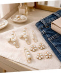 Eight Piece Pearl Waist Tightener Pin Set Elegant Alloy Dress Cincher Clips on a table with denim and accessories.
