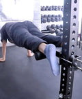 Person using upgrade hamstring curl sit up bar attachments for power racks with pin rod and 3 adjustable holes for core workout
