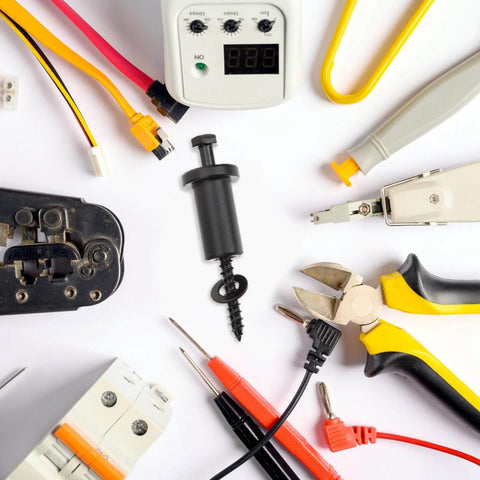 Assorted electrical tools and connectors on white background, including pliers, screwdrivers, and voltage meter.