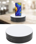 Spiffy Omquot Electric Rotating Jewelry Stand With 360 Degree Swivel Plate And Usb Charging Port For Watches Cosmetics And Toys In Sleek Black Finish, ABS material with a white top and controls, showcasing a phone.