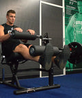 Man using Plate Loaded Leg Extension And Curl Machine For Home Gym Seated Leg Curl And Quad Extension With 180 lb plate load.