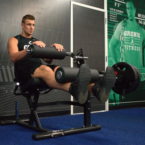 Man using Plate Loaded Leg Extension And Curl Machine For Home Gym Seated Leg Curl And Quad Extension With 180 lb plate load.