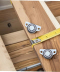 Set Of Four Heavy Duty Adjustable Sliding Door Rollers With Precision Bearings Buttery Smooth Glide Easy Side Or Vertical Mounting On Closets Barn Doors on wood with measuring tape.