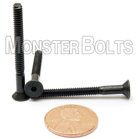 Close-up of Six-32 By One-And-One-Half Inch Flat Head Socket Cap Screws, Alloy Steel With Black Oxide, Partial Thread, Hex Drive next to a penny.