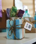 Heavy Duty Square Labels For Labelwriter Printers Hella Strong Sticky Backing Barcode Stickers One Inch Direct Thermal Adhesive bulk roll displayed on a stacked soap cube.