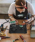 Person using Two In One Magnetic Soldering Third Hand With Heavy Duty Metal Workbench Vise PCB Circuit Board Holder 5X Magnifying Lamp Kit