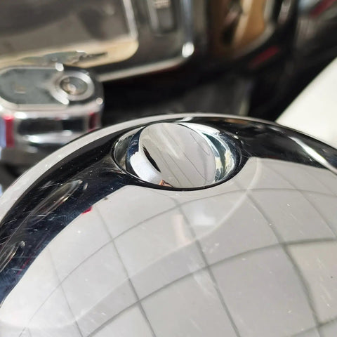 Close-up of Chrome Push Button Fuel Door Gas Cap Latch Kit for Electra Glide, polished surface reflecting surroundings