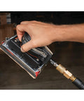 Hand holding Top Shelf Pneumatic Orbital Sander With Built In Air Regulator and Rubber Over Mold Grip for precise sanding.