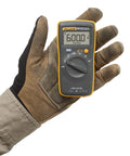 Gloved hand holding Compact Digital Multimeter With 0.5 Percent DC Accuracy, CAT III 600 V Safety, Diode And Continuity Test