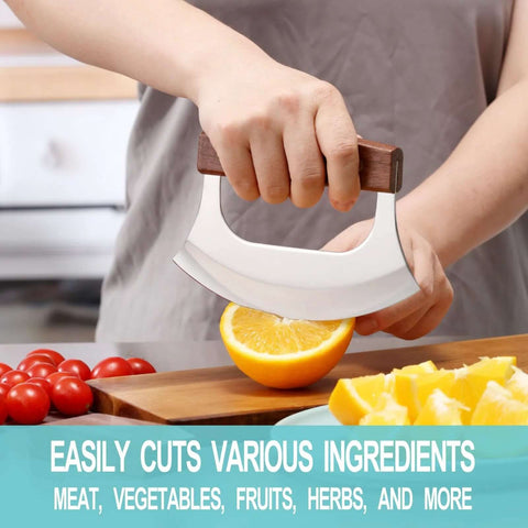 Rocking mezzaluna knife with walnut wood handle and stainless steel curved blade slicing an orange on a cutting board.
