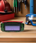 Top Shelf Auto Darkening Welding Goggles With Rugged Impact Resistant Lens For Hardcore Industrial And Garage Work placed on wooden table.