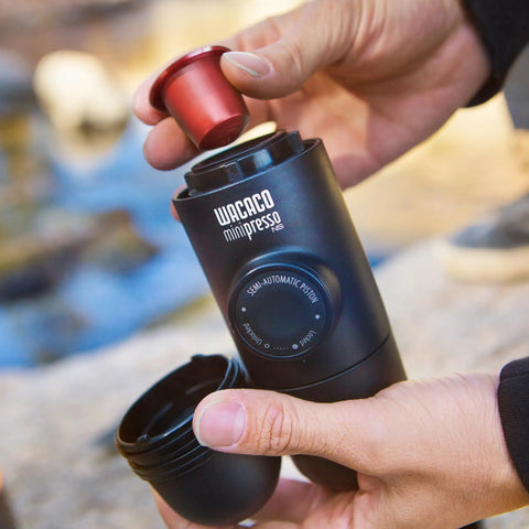 Person using Portable Hand Powered Espresso Maker With Manual Piston Action For Travel And Office Brew Compatible With Original NS Capsules