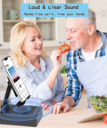 Two In One Bluetooth Speaker Phone Stand With Antislip Base And HD Surround Sound on a kitchen counter with people nearby.
