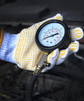 Hand holding universal oil pressure tester kit gauge