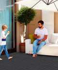 Interlocking Plastic Deck Tiles 36 Sq Ft Pack 36 12 by 12 Inches Waterproof Outdoor Flooring on porch with people relaxing