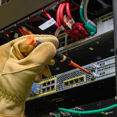 Electrician using 8-In-1 Insulated Screwdriver Set With Case 1000V Rated on server rack, wearing safety gloves.