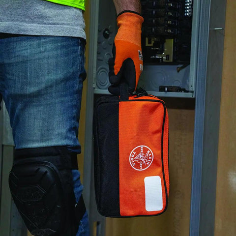 Heavy Duty Tool Pouch With Dual Compartments For Quick Organization Of Meters Leads Sockets Wrenches And Small Parts In A Tough As Nails Multipurpose Tool Bag You Can Count On held by a worker in front of an electrical panel