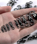 30 Pack Ball Bearing Swivels For Fishing Tackle Heavy Duty Stainless Steel Welded Rings Barrel Swivel Hook Line Connector With Black Nickel Coating Saltwater And Freshwater Ready Size 0 Twist Free 360 Degree Rotation, shown in hand