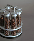 Eight Single Dose Espresso Bean Storage Tubes With Rotating Display Rack And Precision Funnel Set showcasing glass tubes filled with coffee beans.