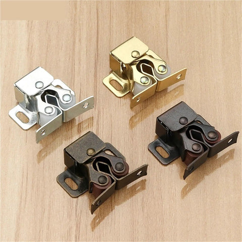 Four metal Magnet Cabinet Catch Door Stop Closer Damper Buffer for Wardrobe Hardware And Furniture Fittings on wooden surface.