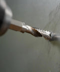Close-up of No Nonsense Combination Drill Tap And Countersink Bit For Up To 10 Gauge Metal drilling into metal surface.