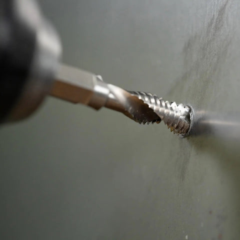 Close-up of No Nonsense Combination Drill Tap And Countersink Bit For Up To 10 Gauge Metal drilling into metal surface.