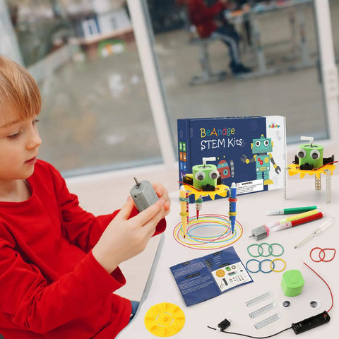 Boy in red shirt assembling Four Pack Doodling Robot Kit For Kids Ages Eight To Twelve, Bulk STEM Toys For Hands On Learning, Build Four Doodle Robots, Fun Do It Yourself Science Tech Engineering Math Projects.