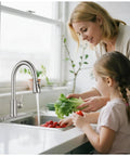 Slick Brushed Nickel Kitchen Faucet With Pull Down Sprayer High Arc Spout 18 Inch Hose, mom and daughter washing veggies in sink.